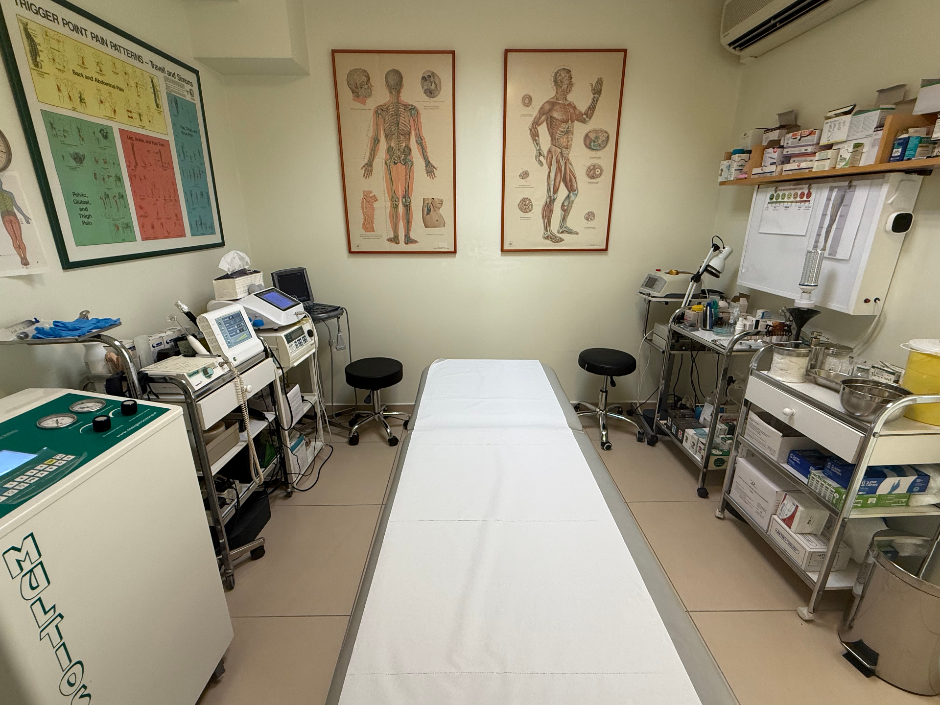 Χώρος εξέτασης με ιατρικό εξοπλισμό και αφίσες ανατομίας στο Πρότυπο Νευρολογικό Κέντρο
